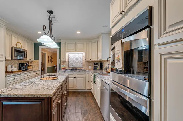 a kitchen with granite countertop stainless steel appliances and wooden cabinets