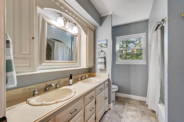 a bathroom with a granite countertop sink mirror vanity and toilet