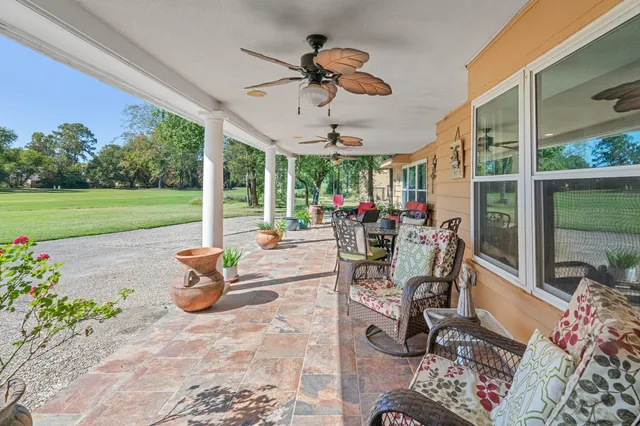 a view of a patio with chairs and table potted plants