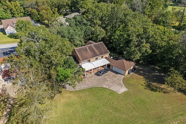 an aerial view of a house with a yard and lake view