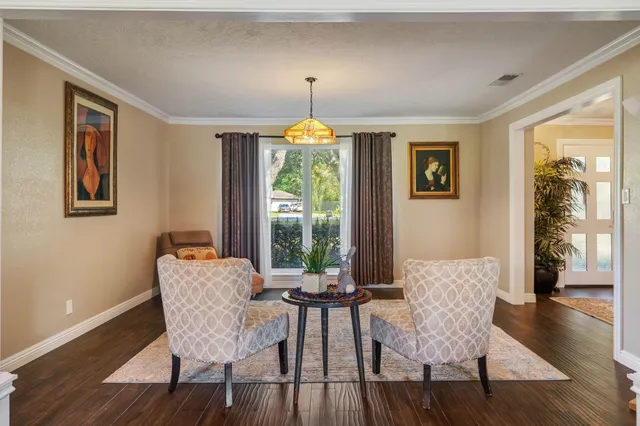 a dining room with furniture a chandelier and wooden floor