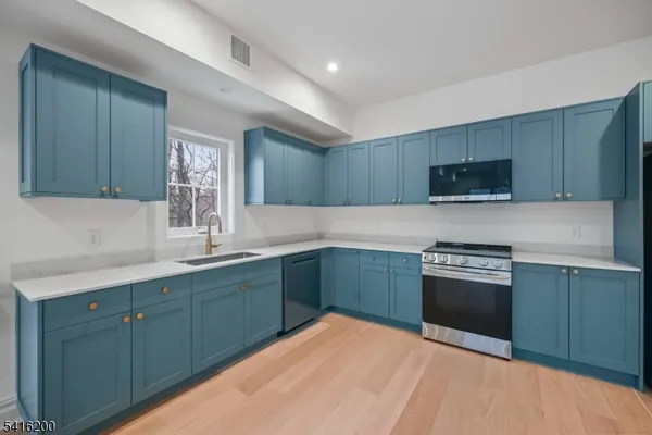 a kitchen with stainless steel appliances granite countertop a sink stove and microwave