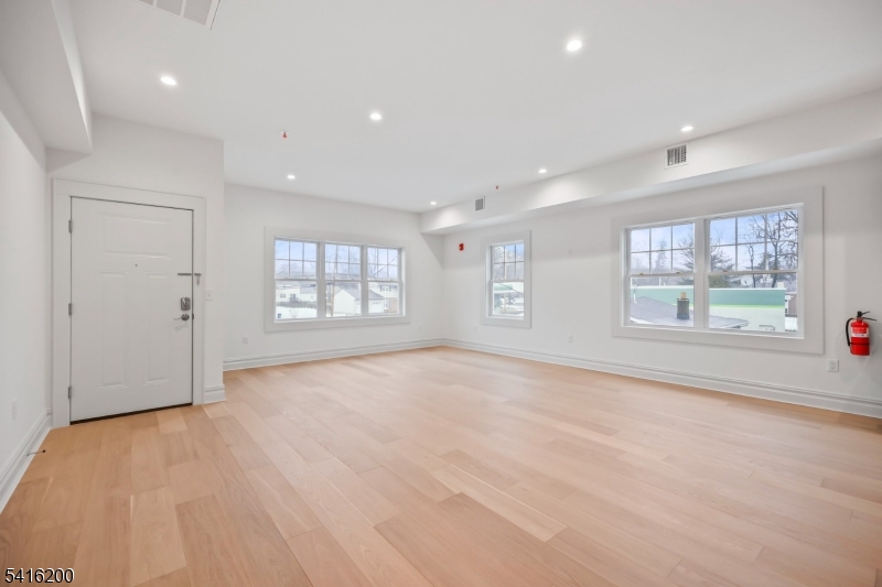 1209 Littleton Road, Unit D Morris Plains, NJ 07950 - Photo 5 of 23 a view of an empty room with a window and wooden floor
