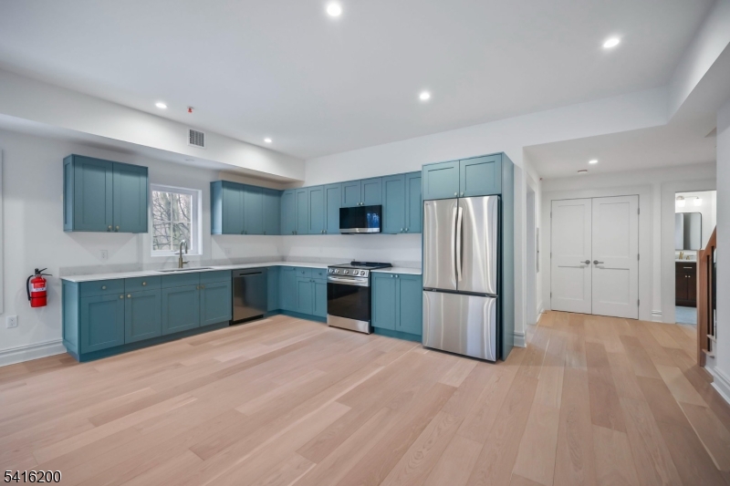 1209 Littleton Road, Unit D Morris Plains, NJ 07950 - Photo 9 of 23 a kitchen with stainless steel appliances kitchen island a refrigerator sink and cabinets