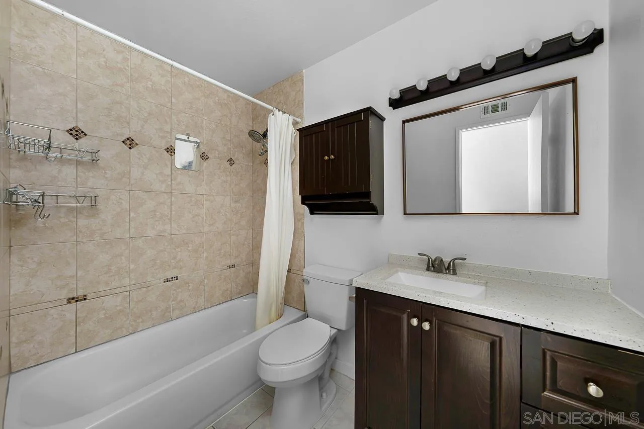 9927 Sadie Street Santee, CA 92071 - Photo 15 of 29 a bathroom with a toilet a sink a mirror a bathtub and vanity