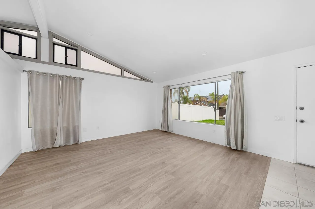 9927 Sadie Street Santee, CA 92071 - Photo 4 of 29 a view of an empty room with wooden floor and windows
