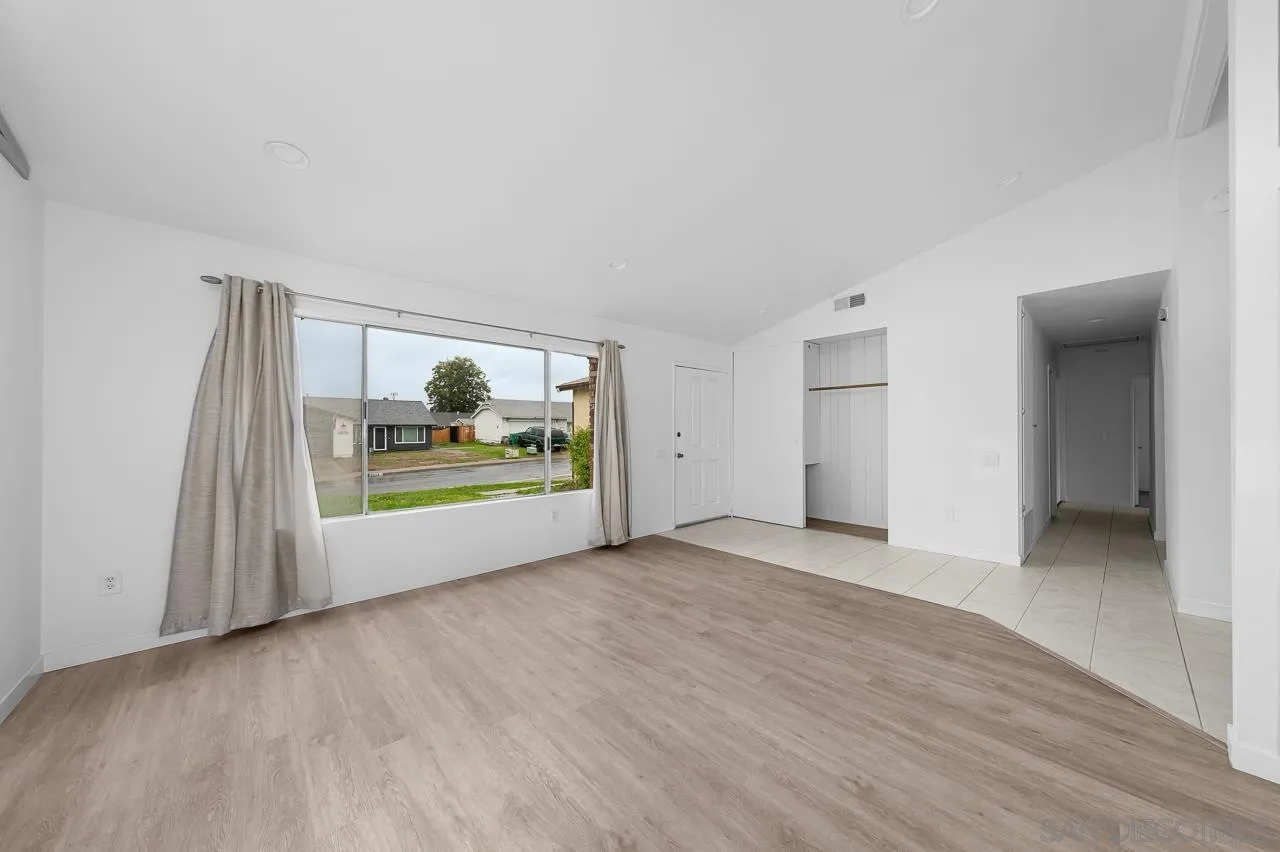 9927 Sadie Street Santee, CA 92071 - Photo 6 of 29 a view of an empty room with a window and wooden floor