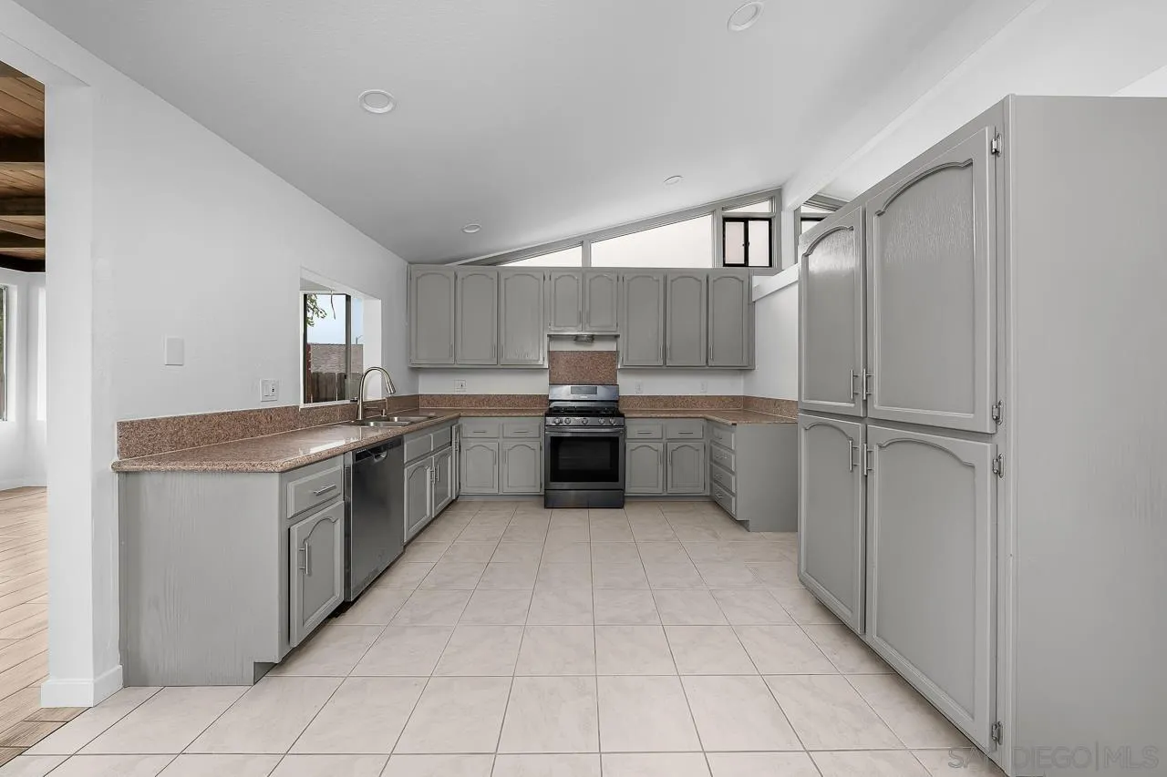 9927 Sadie Street Santee, CA 92071 - Photo 10 of 29 a kitchen with granite countertop a refrigerator and white cabinets