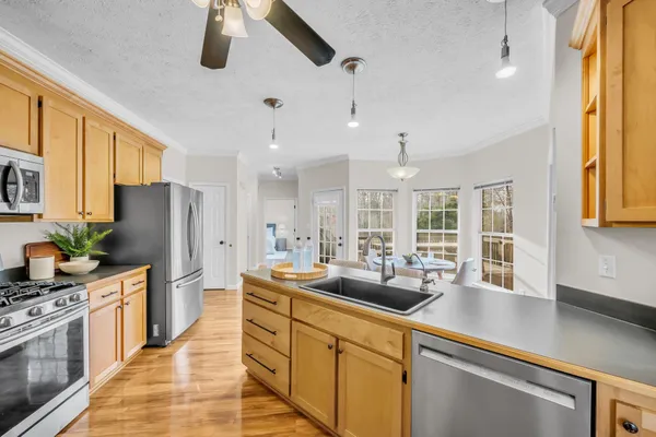a kitchen with stainless steel appliances kitchen island granite countertop a sink and cabinets