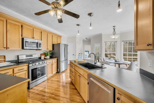 a kitchen with stainless steel appliances granite countertop a sink a stove and a refrigerator