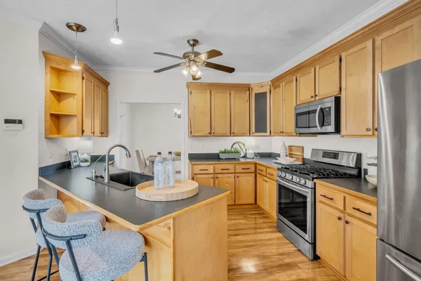 a kitchen with stainless steel appliances granite countertop a sink stove and refrigerator