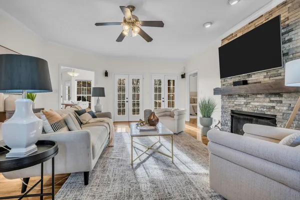 a living room with furniture a flat screen tv and a fireplace