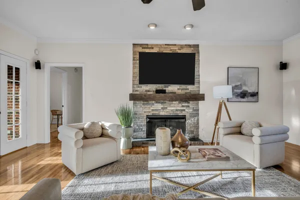 a living room with furniture a flat screen tv and a fireplace