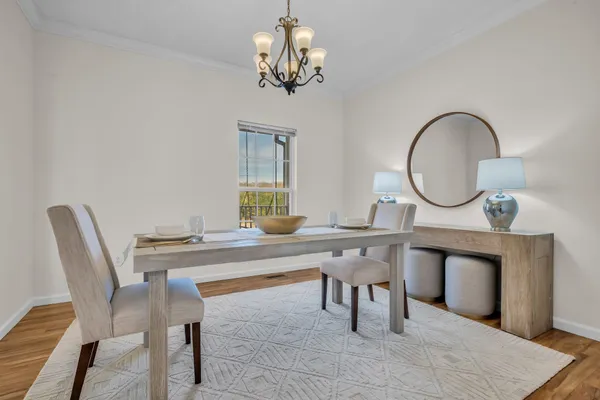 a view of a dining room with furniture a chandelier and wooden floor