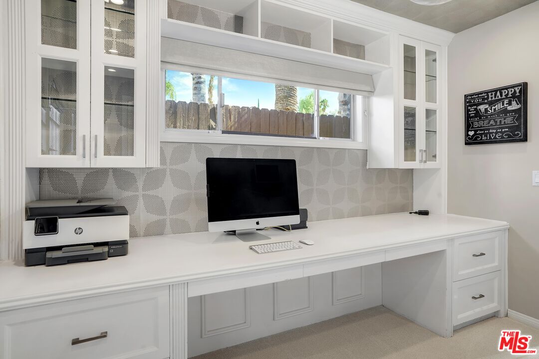 16722 Adlon Road Encino, CA 91436 - Photo 14 of 36 a sink with white cabinets and a fireplace