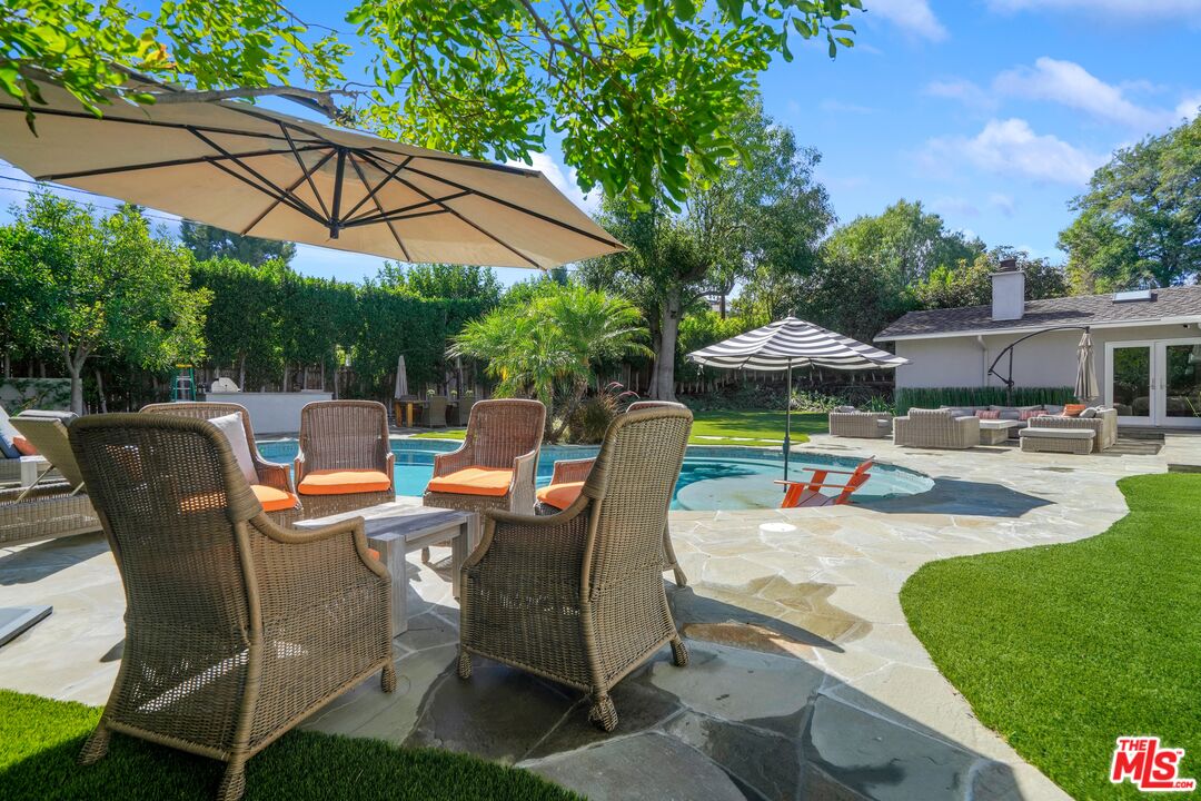 16722 Adlon Road Encino, CA 91436 - Photo 29 of 36 a view of a patio with table and chairs under an umbrella