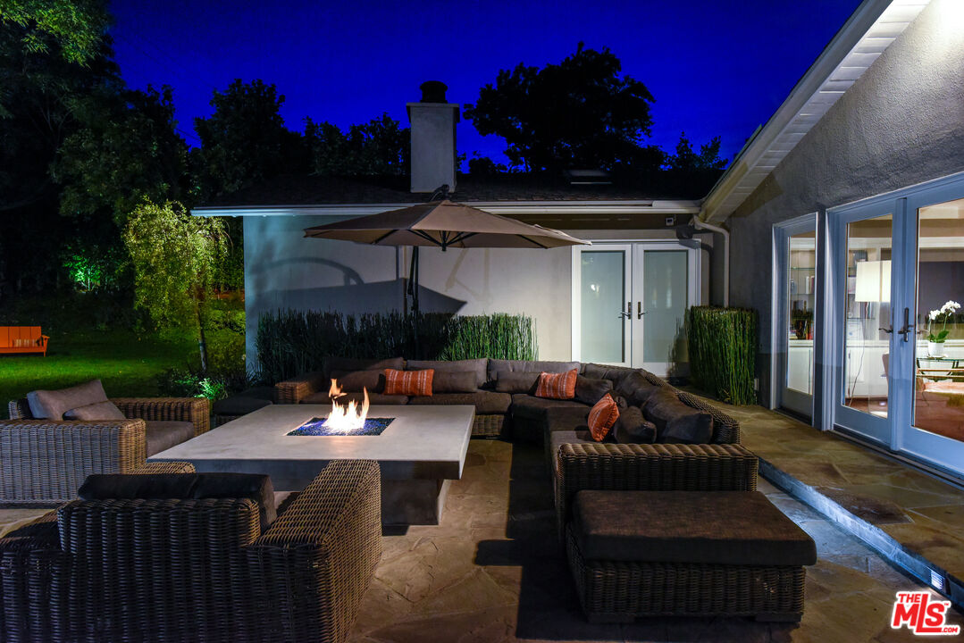 16722 Adlon Road Encino, CA 91436 - Photo 35 of 36 a view of a patio with couches and table and chairs with wooden fence and floor