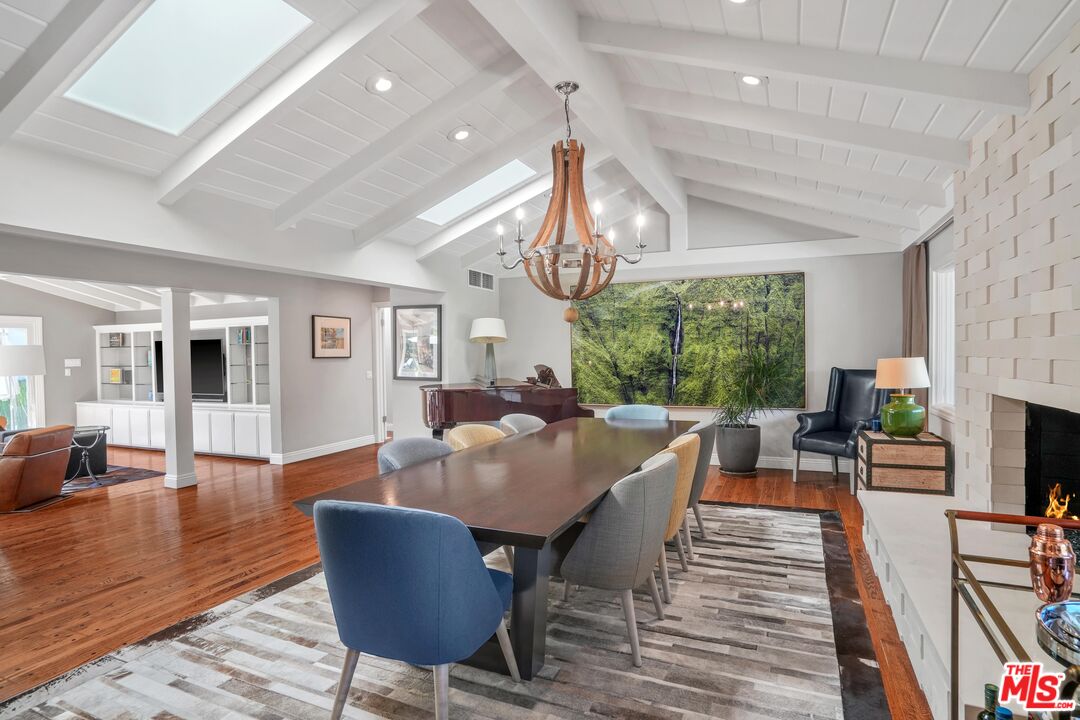 16722 Adlon Road Encino, CA 91436 - Photo 4 of 36 a dining room with wooden floor a chandelier a glass table and chairs