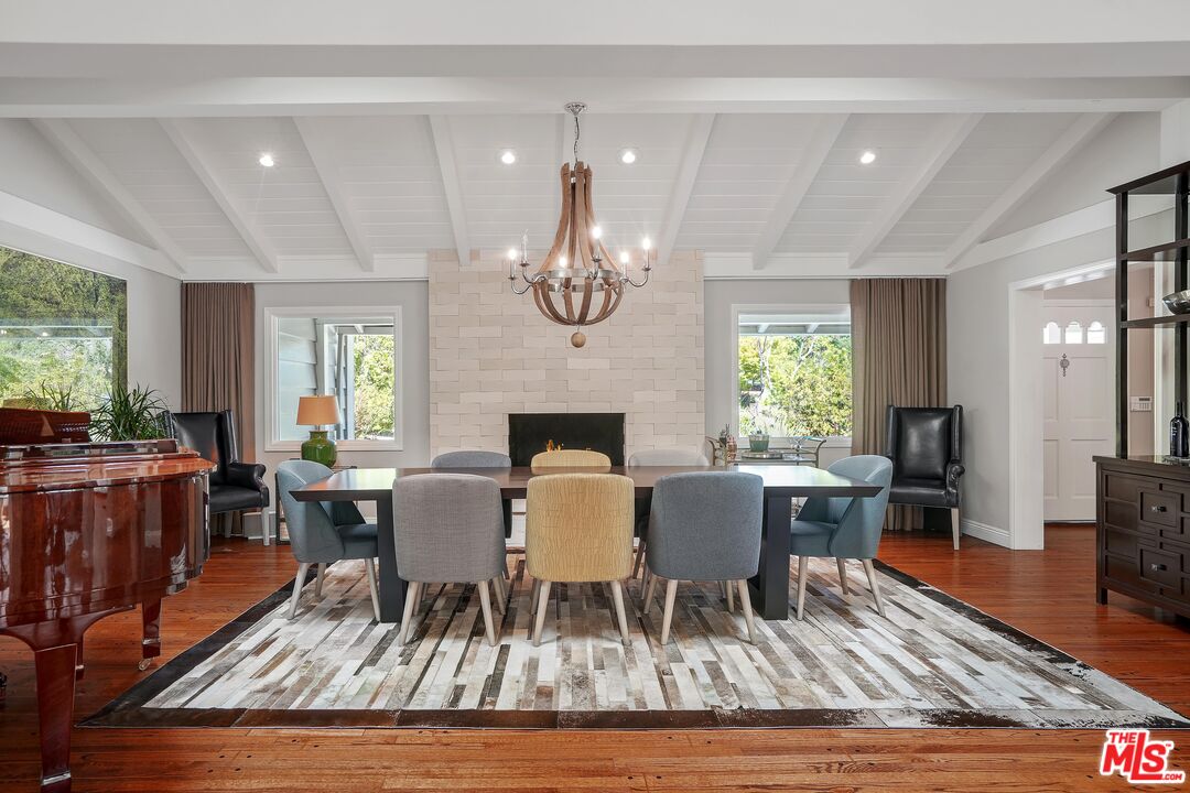 16722 Adlon Road Encino, CA 91436 - Photo 5 of 36 a dining room with wooden floor a chandelier a wooden table and chairs
