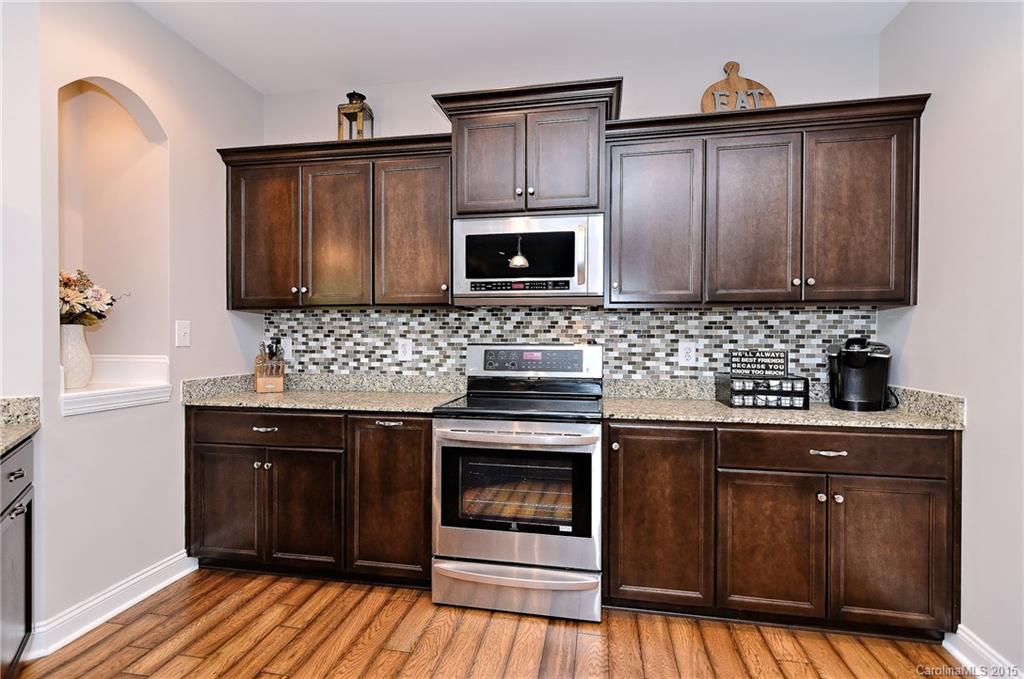 3321 Bridgewick Road Waxhaw, NC 28173 - Photo 7 of 24 a kitchen with granite countertop a stove top oven microwave and cabinets