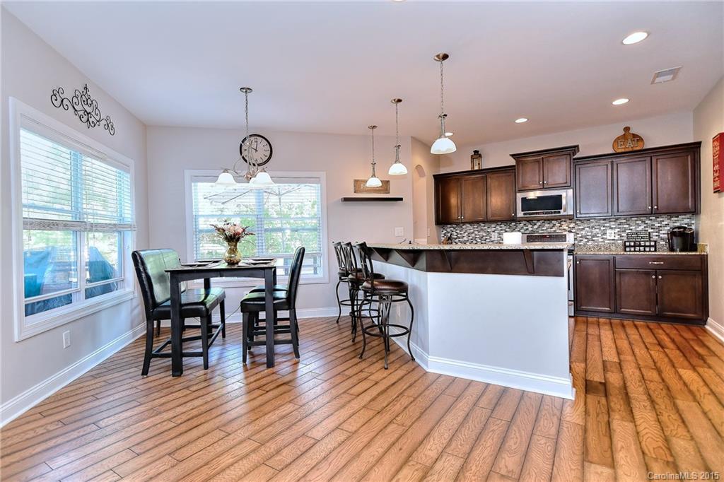 3321 Bridgewick Road Waxhaw, NC 28173 - Photo 9 of 24 a kitchen with stainless steel appliances granite countertop wooden floor a dining table and chairs