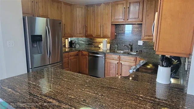 a kitchen with stainless steel appliances granite countertop a refrigerator sink and cabinets