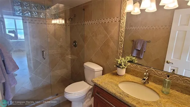 a bathroom with a granite countertop sink toilet and shower