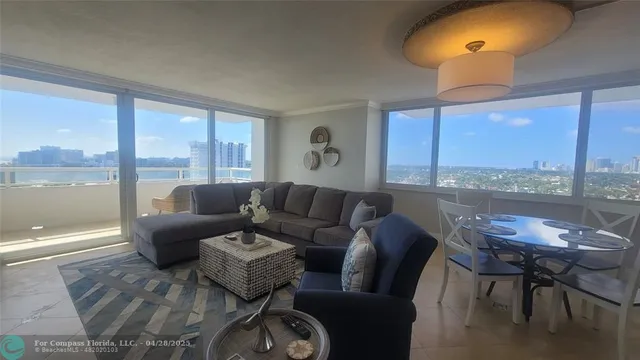 a living room with furniture a large window and a table