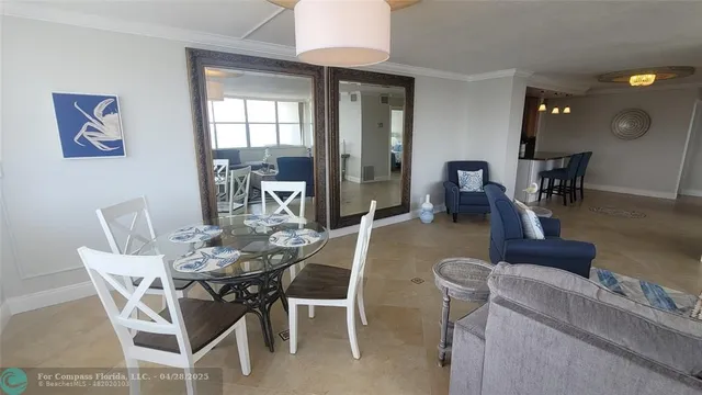 a dining room with furniture and a large window