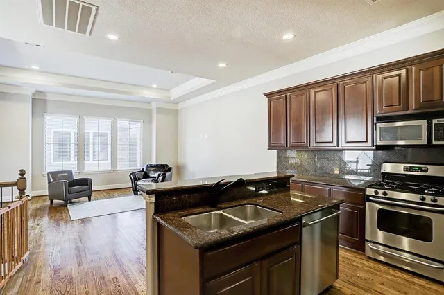 a kitchen with stainless steel appliances kitchen island granite countertop a refrigerator and a stove top oven