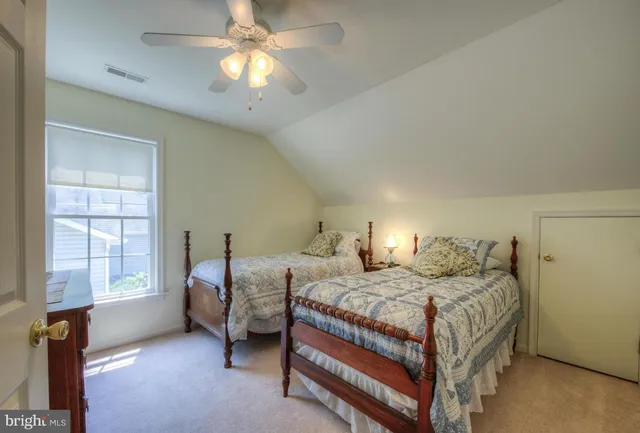 a bedroom with two beds and a chandelier