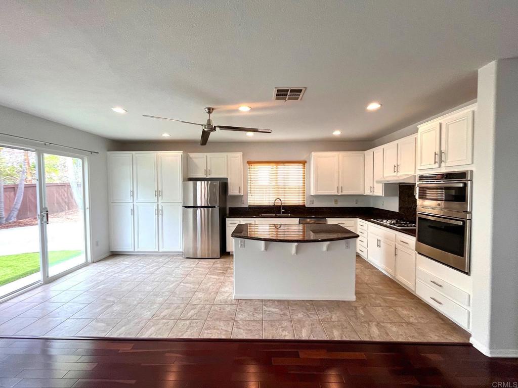 3840 Stoneridge Road Carlsbad, CA 92010 - Photo 11 of 36 a kitchen with a refrigerator and a stove top oven