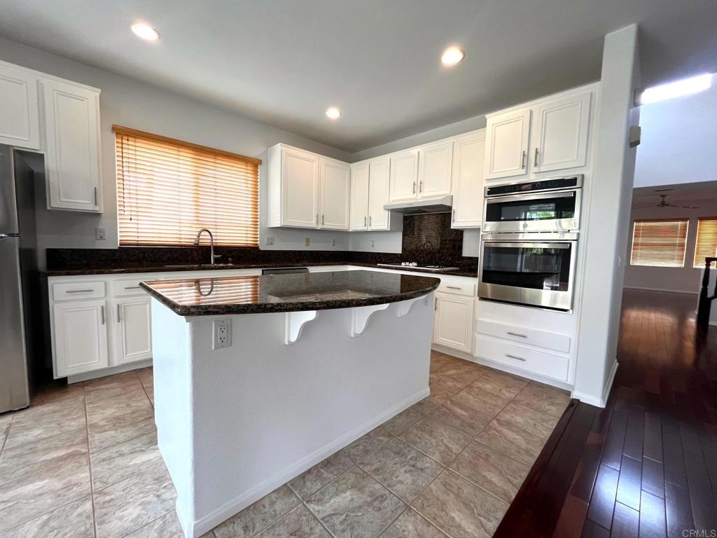 3840 Stoneridge Road Carlsbad, CA 92010 - Photo 12 of 36 a kitchen with stainless steel appliances granite countertop a sink a stove a microwave a sink a refrigerator and cabinets