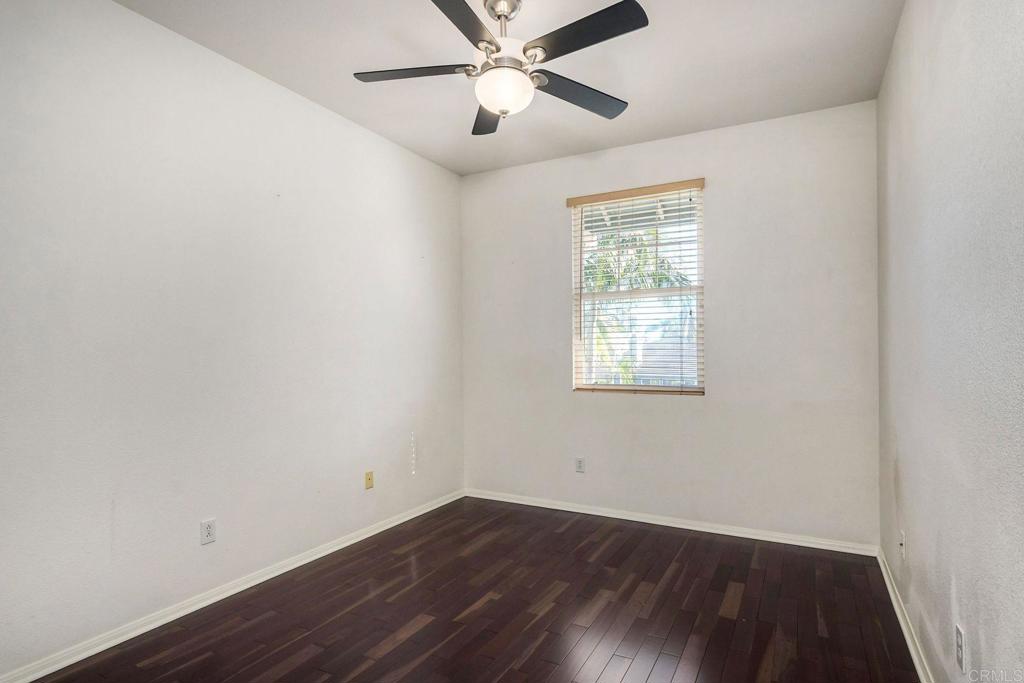 3840 Stoneridge Road Carlsbad, CA 92010 - Photo 17 of 36 an empty room with wooden floor ceiling fan and windows