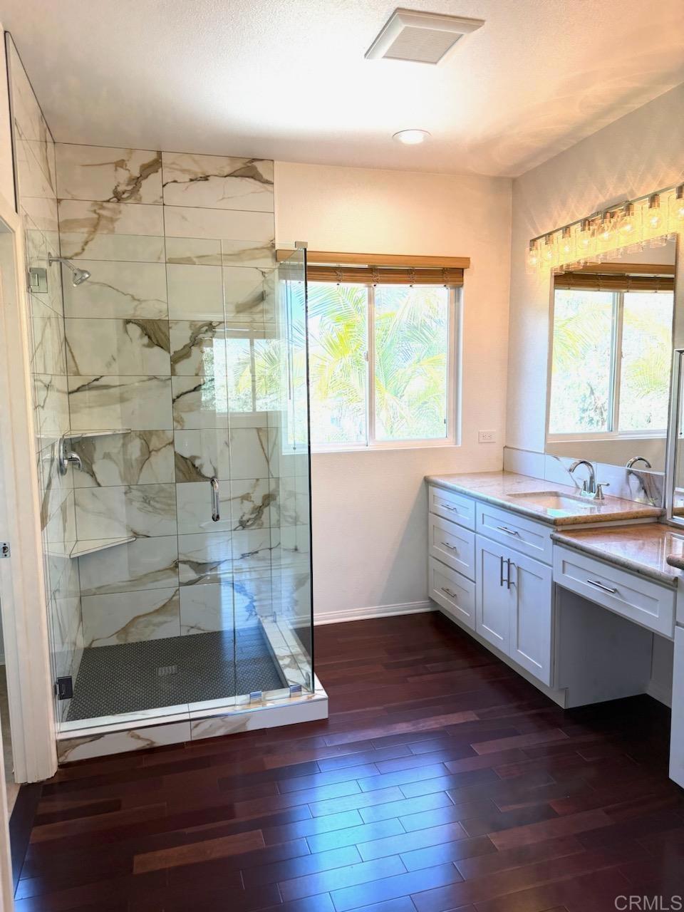 3840 Stoneridge Road Carlsbad, CA 92010 - Photo 26 of 36 a bathroom with a double vanity sink a large mirror and shower