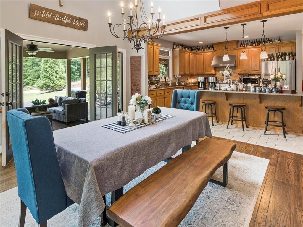 253 Happy Trails Way Jasper, GA 30143 - Photo 89 of 147 a dining room with wooden floor a chandelier table and chairs