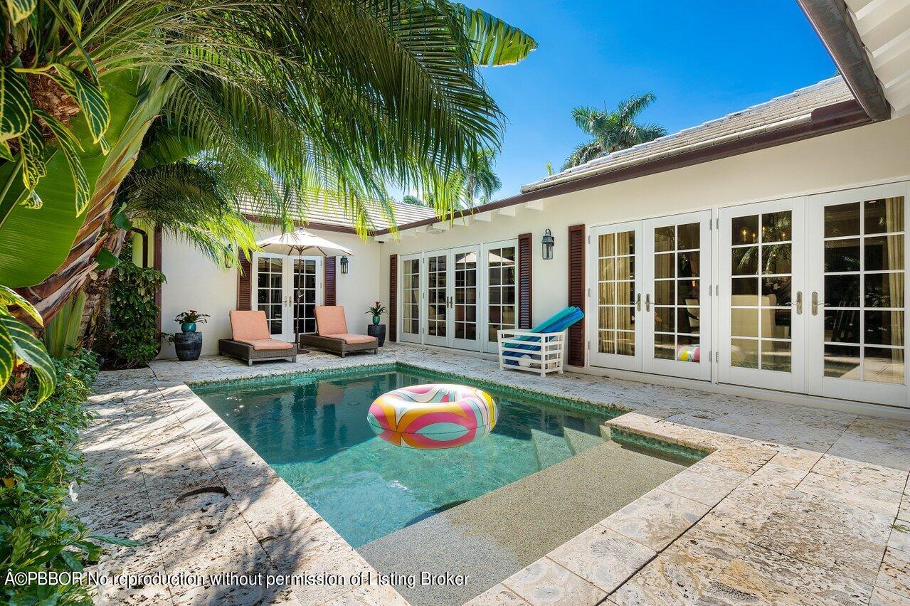 265 List Road Palm Beach, FL 33480 - Photo 32 of 39 a front view of a house with swimming pool having outdoor seating