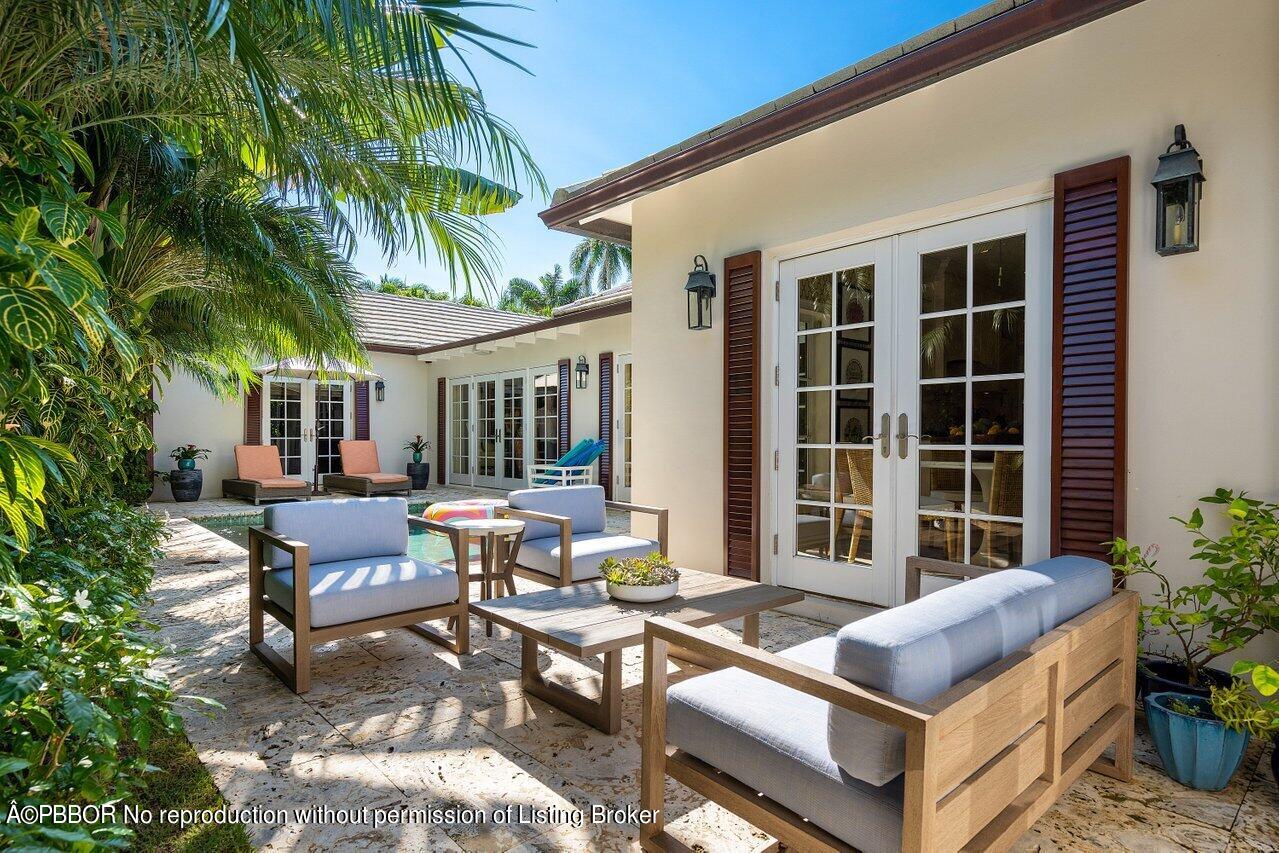 265 List Road Palm Beach, FL 33480 - Photo 33 of 39 a building outdoor space with patio furniture and potted plants