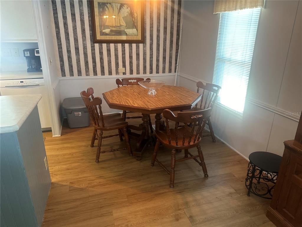 15550 Burnt Store Road, Unit 196 Punta Gorda, FL 33955 - Photo 12 of 62 a view of a dining room with furniture and wooden floor