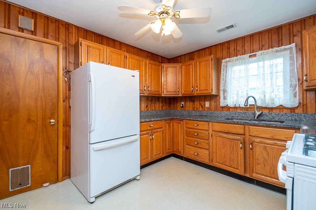 5 Pleasantview Vermilion, OH 44089 - Photo 9 of 37 Kitchen with sink, white refrigerator, dark stone countertops, range, and ceiling fan