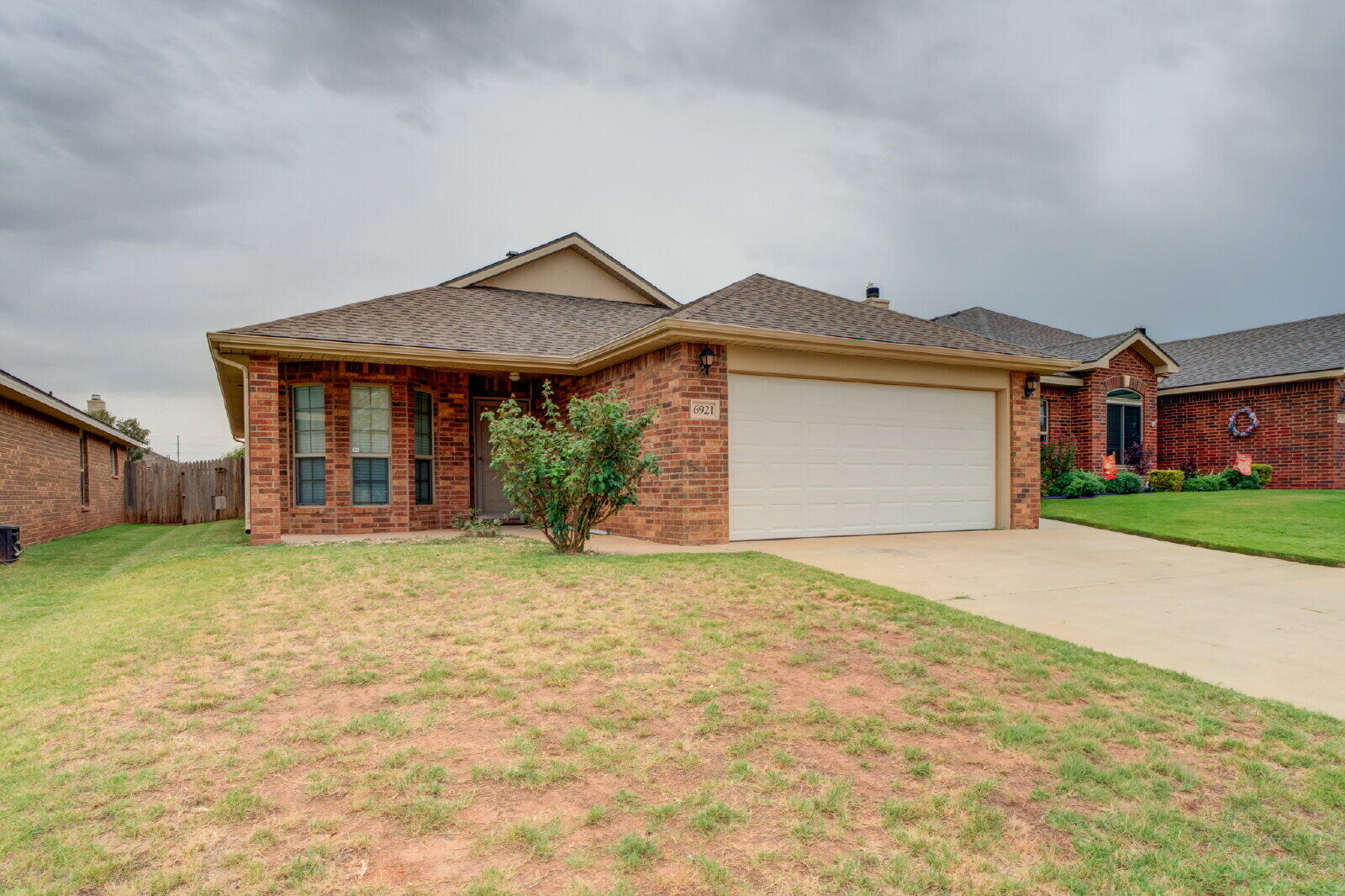 6921 95th Street Lubbock, TX 79424 - Photo 1 of 32 front view of a house with a yard and potted plants