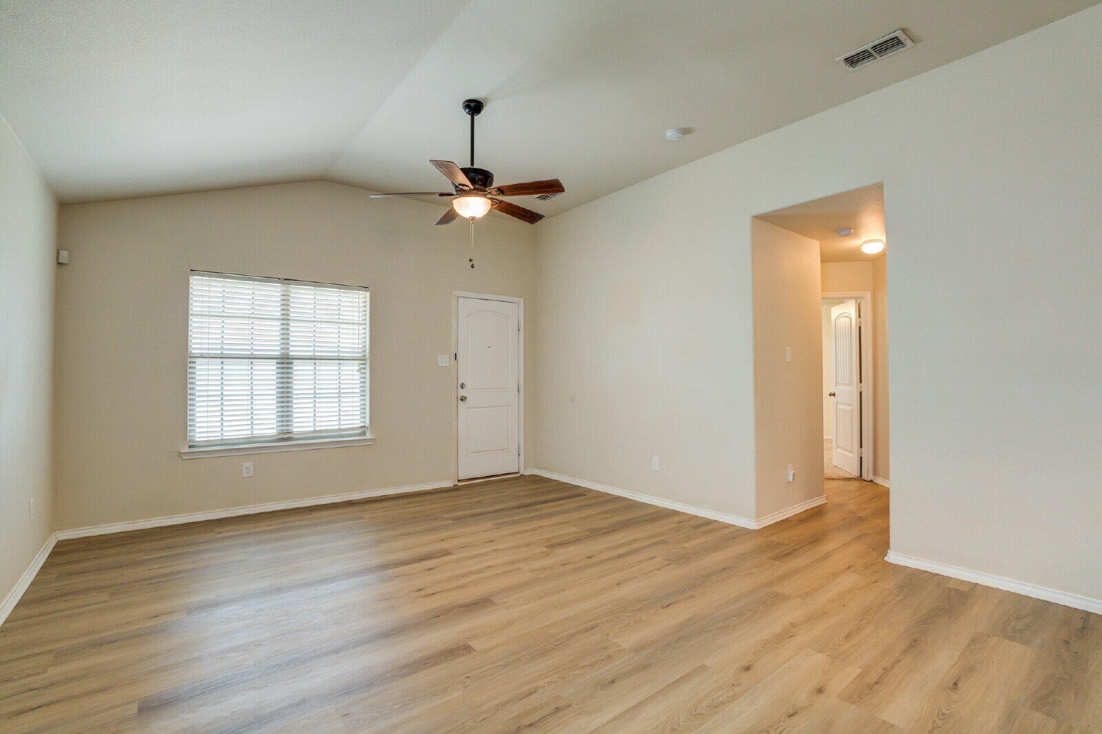 6921 95th Street Lubbock, TX 79424 - Photo 14 of 32 an empty room with wooden floor chandelier and windows