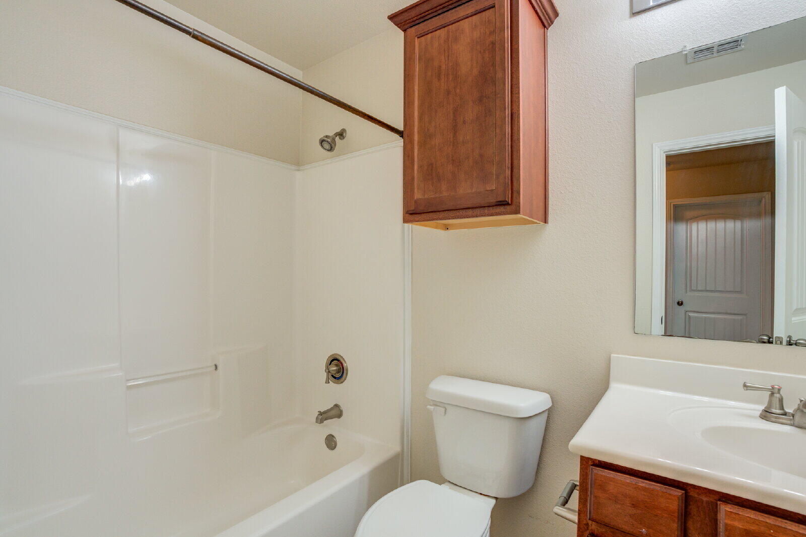 6921 95th Street Lubbock, TX 79424 - Photo 21 of 32 a bath room with a toilet a sink and a bath tub