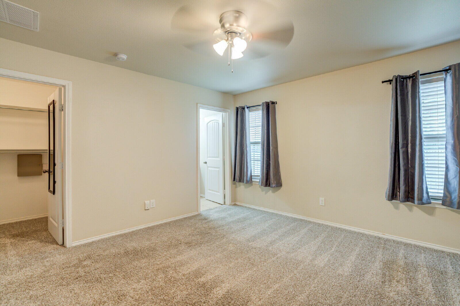 6921 95th Street Lubbock, TX 79424 - Photo 25 of 32 a view of a room with a ceiling fan and a window