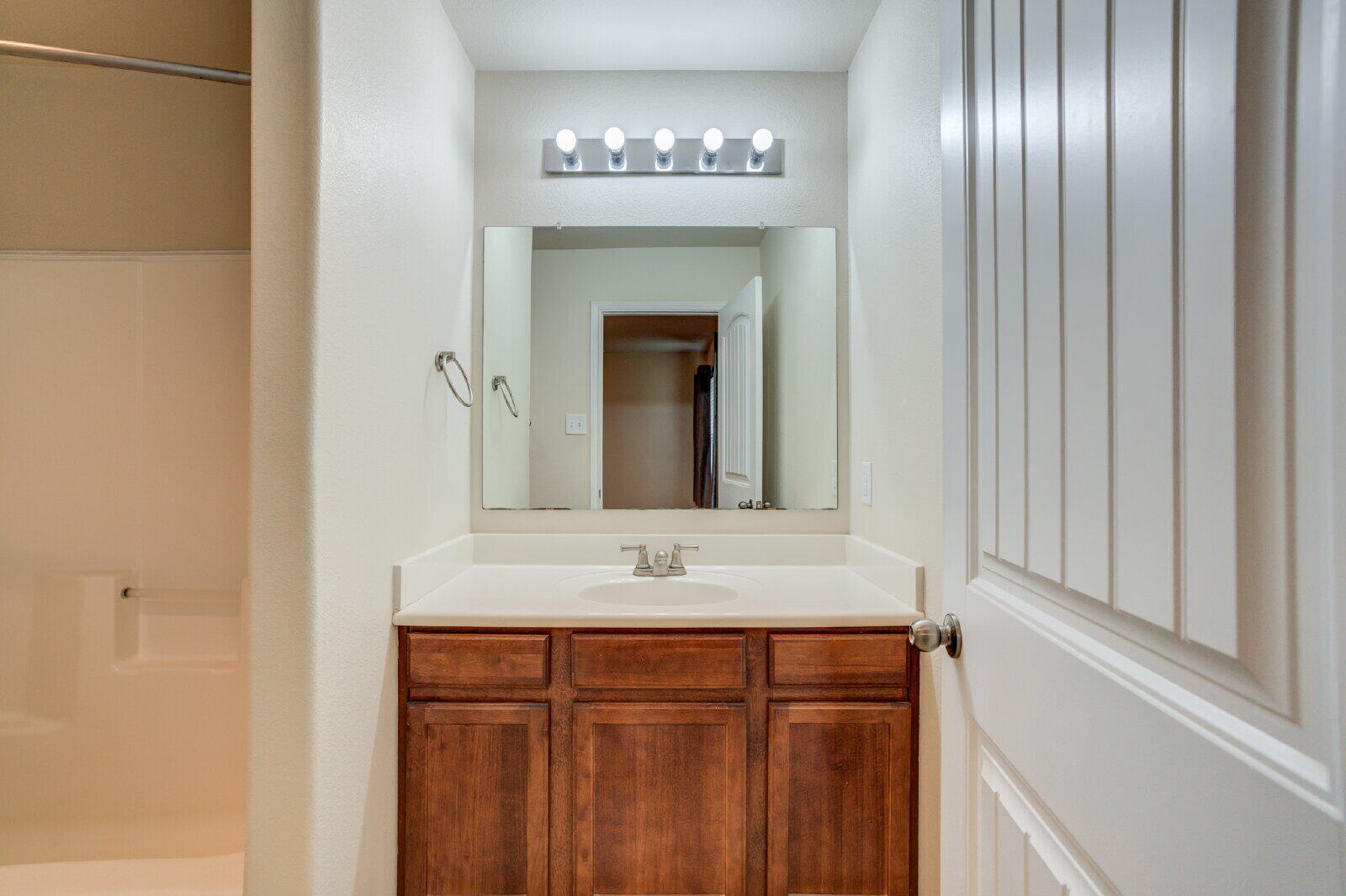 6921 95th Street Lubbock, TX 79424 - Photo 27 of 32 a bathroom with a sink and a mirror