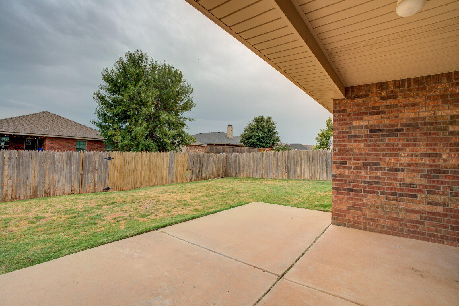 6921 95th Street Lubbock, TX 79424 - Photo 31 of 32 a view of backyard with small cabin and wooden fence