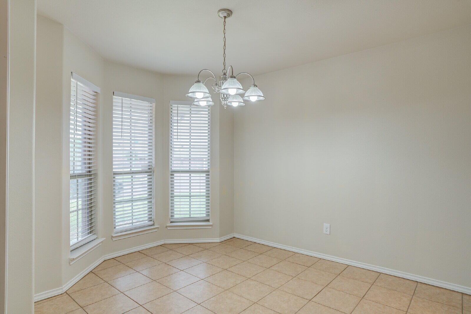 6921 95th Street Lubbock, TX 79424 - Photo 4 of 32 an empty room with windows and chandelier