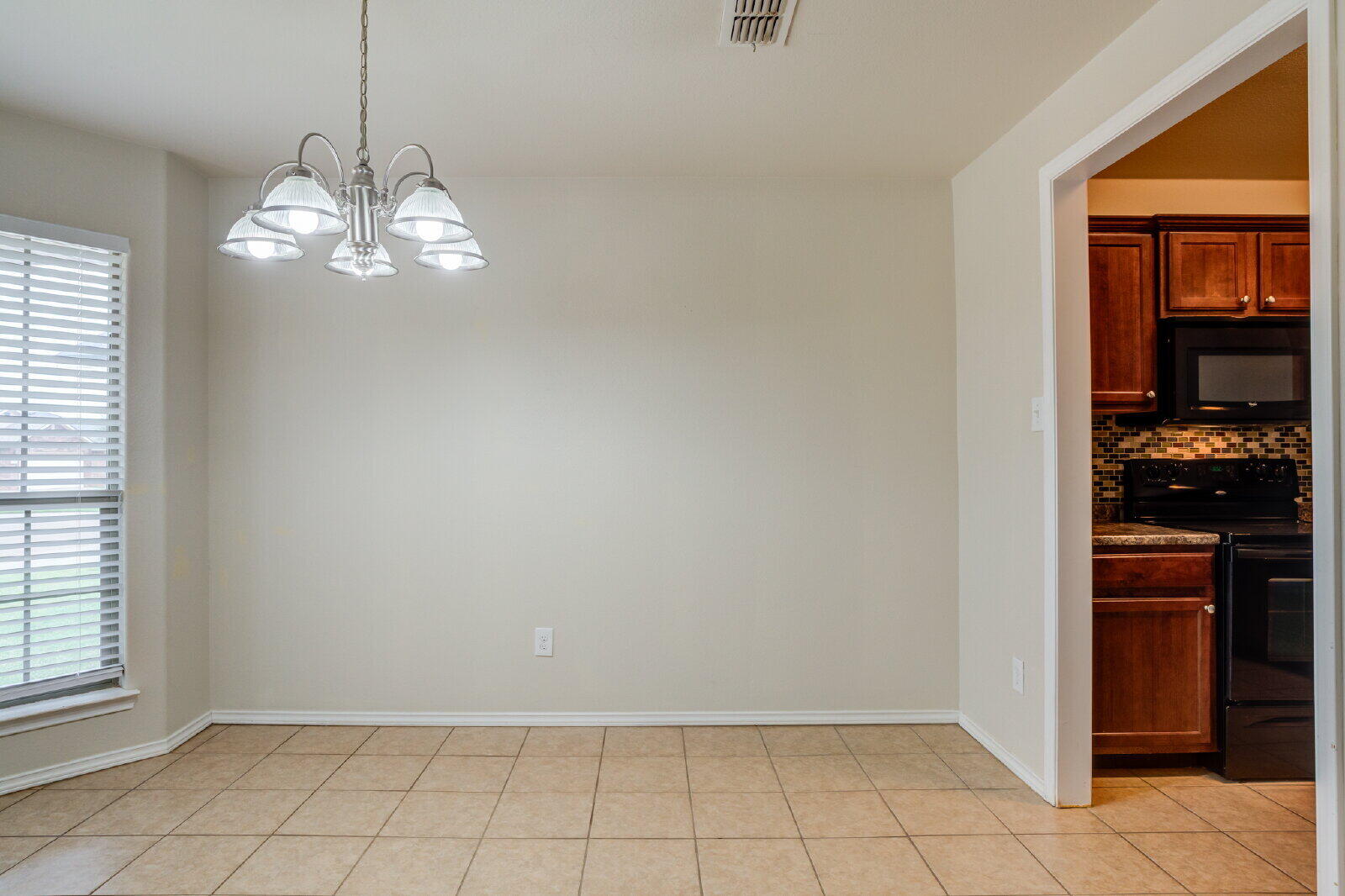 6921 95th Street Lubbock, TX 79424 - Photo 5 of 32 a view of a kitchen with wooden floor and a window