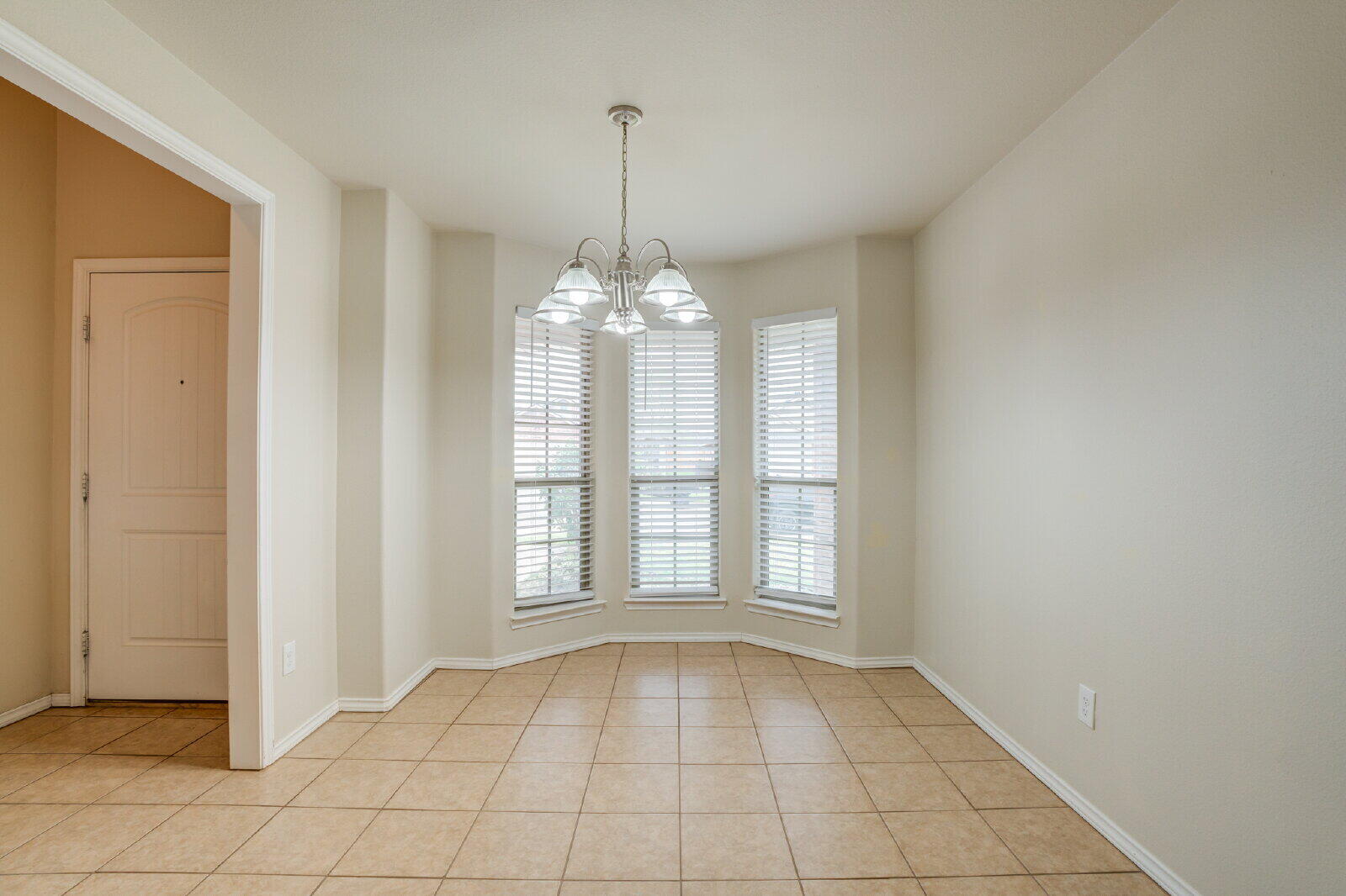 6921 95th Street Lubbock, TX 79424 - Photo 6 of 32 a view of an empty room with window and chandelier fan
