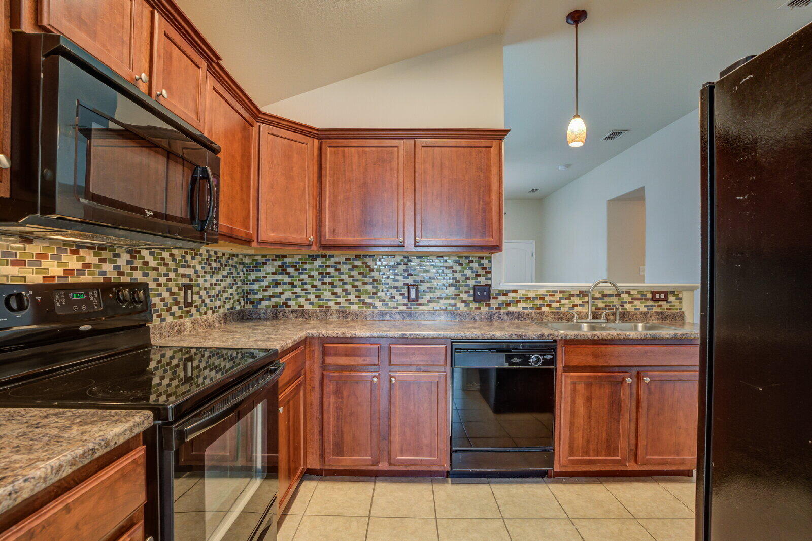 6921 95th Street Lubbock, TX 79424 - Photo 7 of 32 a kitchen with a stove and a microwave